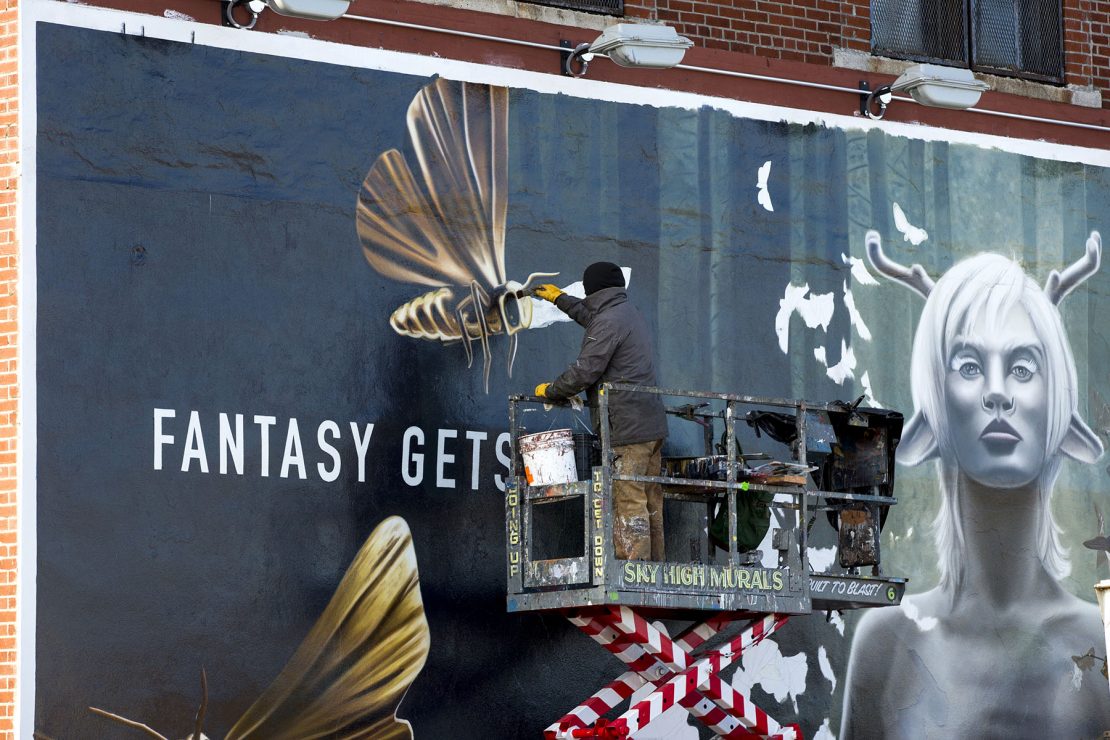 Hand painting an outdoor advertisement for Syfy