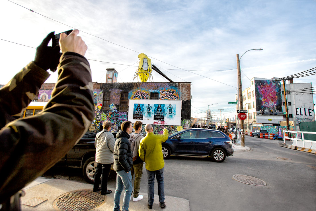 Bushwick street art tour stops to talk about Colossal's hand painted mural
